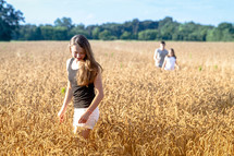 children walking through a field of wheat 