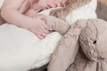 newborn holding a stuffed animal 