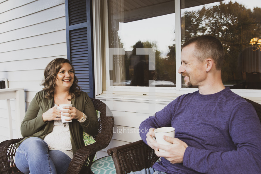 husband and wife having coffee on a front porch 