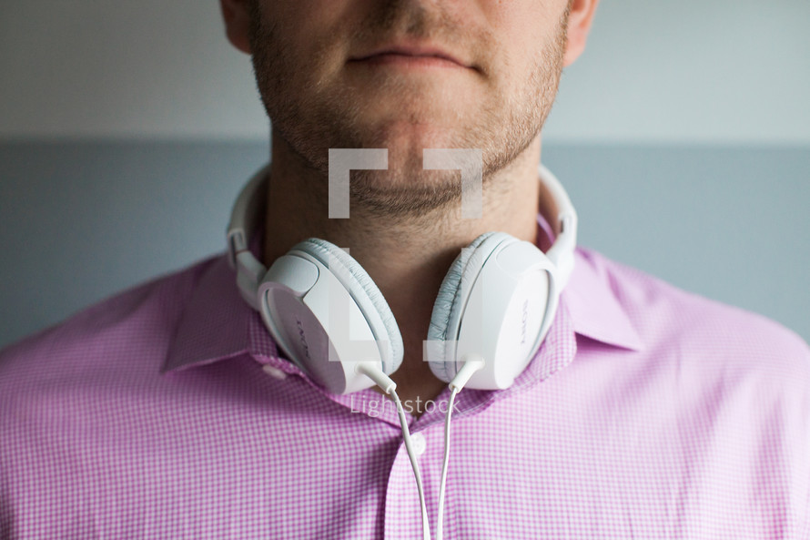 man with headphones around his neck 