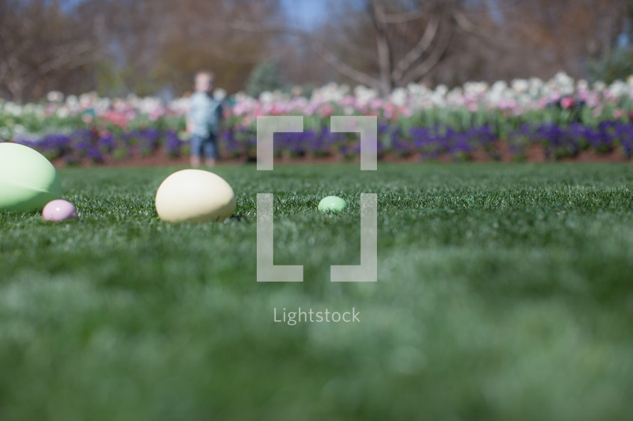 Easter eggs in the grass of a garden of flowers
