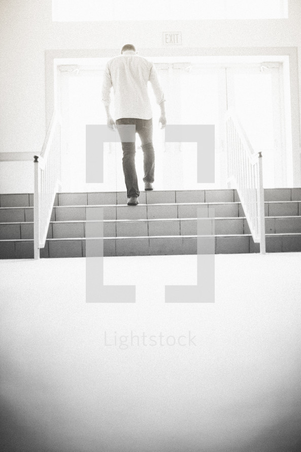 man walking up stairs exiting a church
