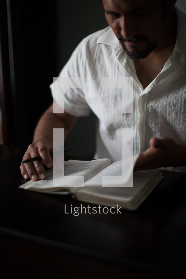 man turning the pages of a Bible 