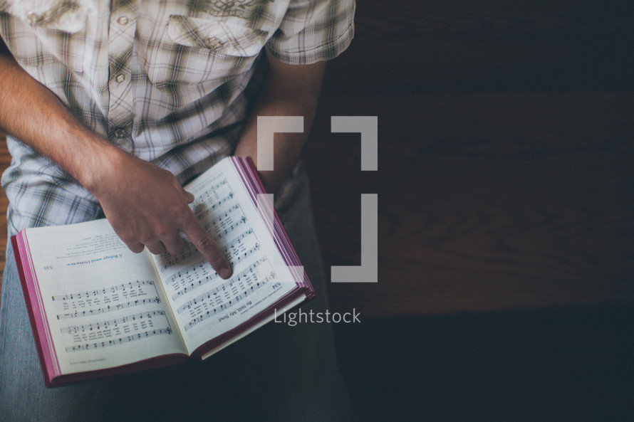 man holding a hymnal 