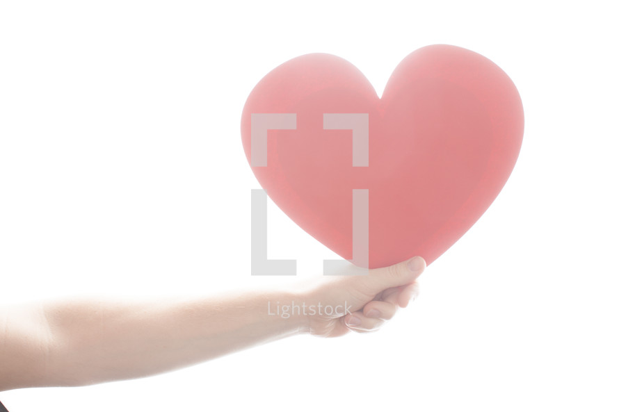 arm holding a large red paper heart 