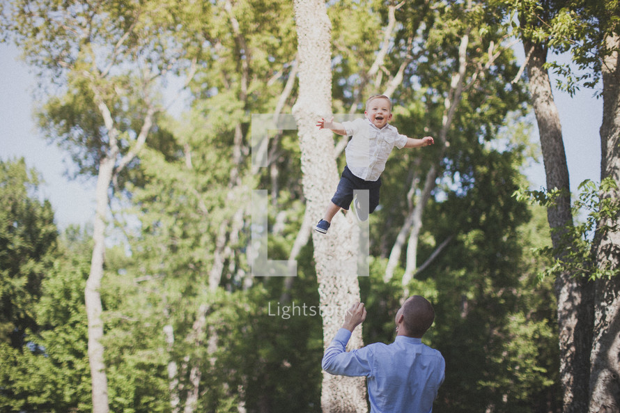 father tossing his son in the air
