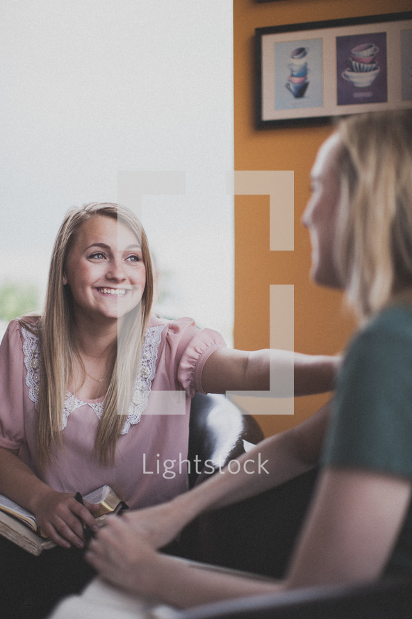 Two smiling women at a Bible study.