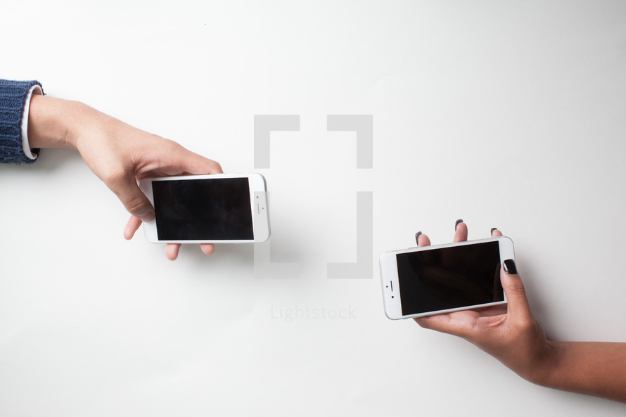 hands holding iPhones 