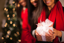 three African American women holding Christmas gifts 