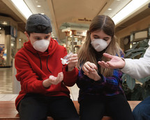 Family Using Hand Sanitizer Wearing Face Masks