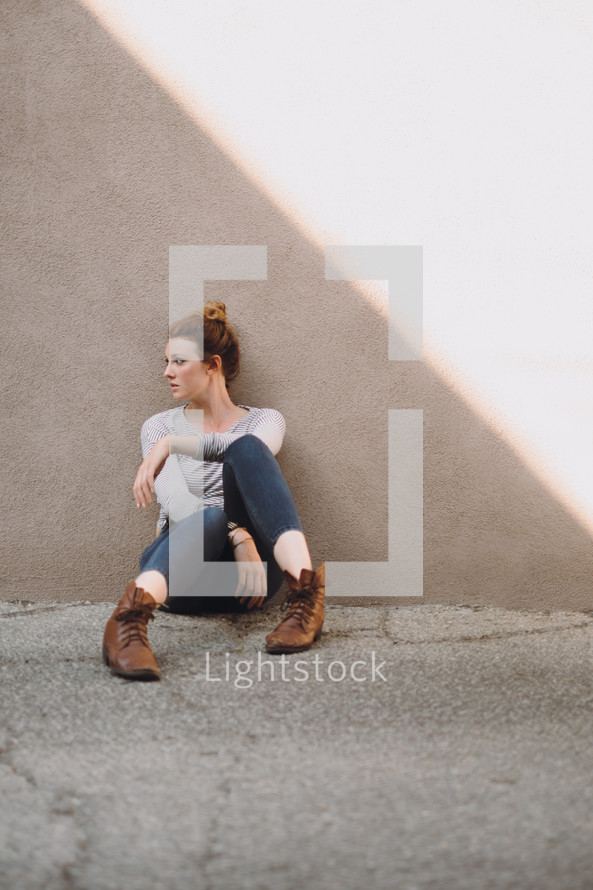 young woman sitting on concrete 