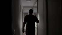 Man With Flashlight Walking Inside Dark House. static shot	