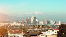 Los Angeles Downtown financial and business towers skyscrapers skyline and mountains in the background, California, 4K. Los Angeles skyline over snowy mountains
