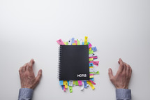 Top view of a man in front of a note pad full of sticky notes 