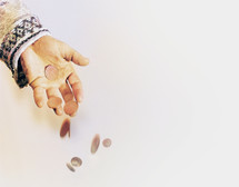 A person's hand throwing coins. Abstract, metaphor