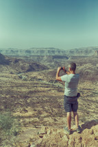 a man taking a picture in a national park 
