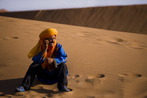 man sitting on sand dunes 