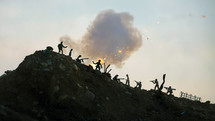 Miniature silhouettes of WWII American and German soldiers being covered by a large explosion. Slow motion
