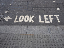 Look Left traffic sign on a London street tarmac