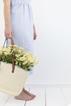a woman holding a bouquet of white daisies 