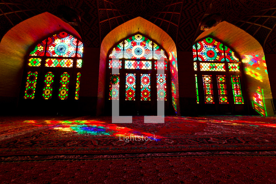 light from stained glass windows shining onto rugs 