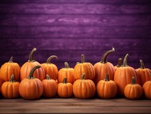 Pumpkins on a wooden table with purple wall in the background