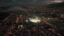 Twilight, aerial view of Atahualpa Olympic Stadium and illuminated Quito city	
