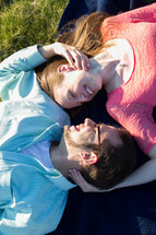 a couple lying on a blanket in the grass