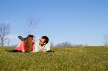 couple lying together on a blanket in grass 