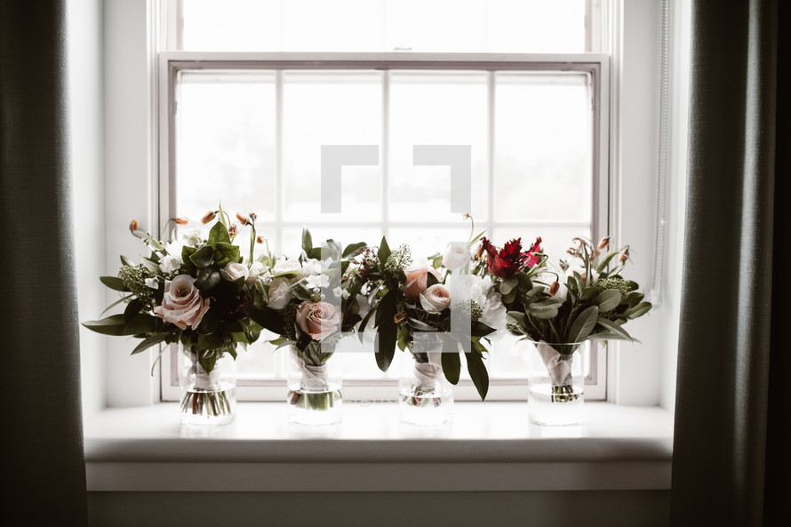 bridal bouquets in vases in a window 