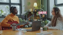 Musician Singing to Guitar during Radio Show in Recording Studio
