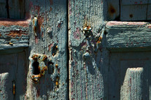 rusty door hinges oom a green wood door 