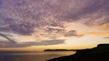 Sunset clouds timelapse over beautiful coastal view