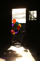 a teen girl sitting with balloons 