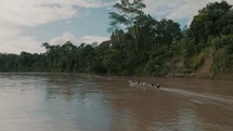 Aerial side view of boat traveling on the Amazon river.