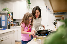 Girl and mom cooking breakfast together 