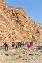 people hiking through a canyon desert 