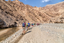 people hiking through a canyon desert 