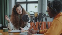 Cheerful Girl Recording Interview with Guest at Podcast Studio
