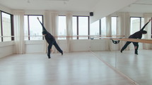 Talented male dancer spinning and practicing floor work, performing expressive contemporary dance alone during rehearsal at the studio
