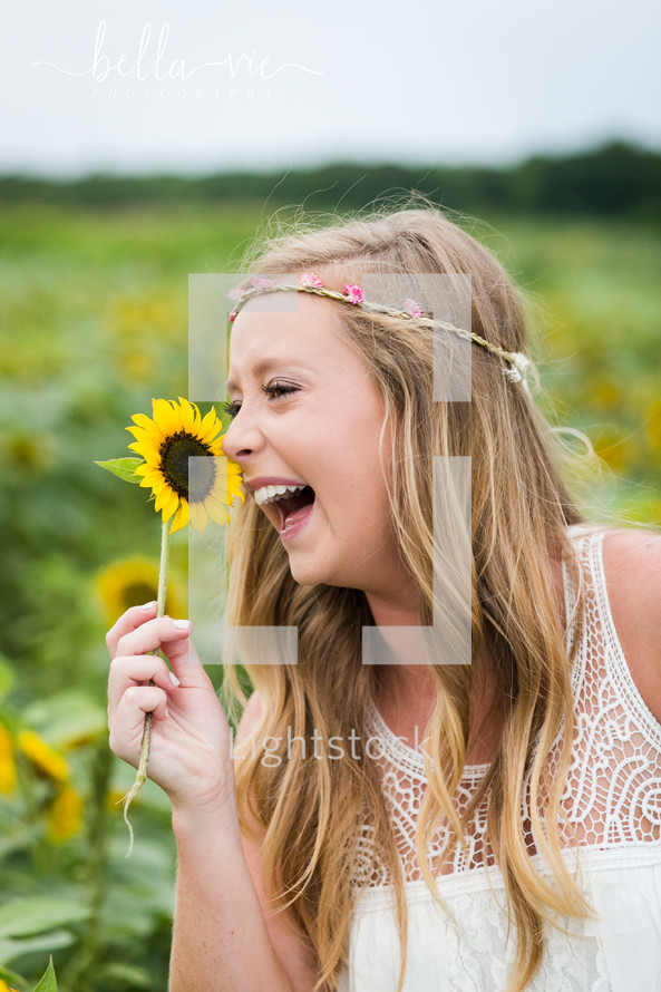 happy young woman holding a sunflower 