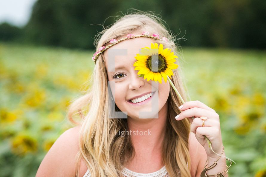 happy young woman holding a sunflower 