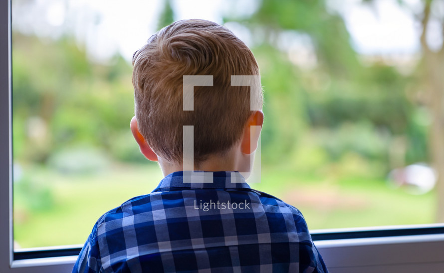 little boy looking out a window, anonymous person