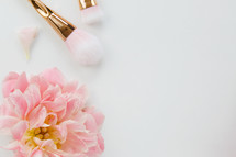 pink spring flowers and makeup brush on a white background 
