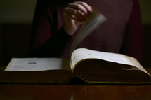 a man turning the pages of a Bible 