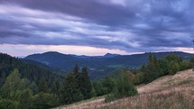 Dramatic Sky with Rain Clouds on the Horizon at Dusk Over a Forest Landscape on a Meadow 