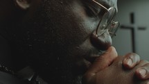 Close-Up Shot of Focused Priest Whispering Prayer with Hands Clasped