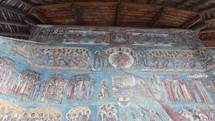 Tilt-down Shot Detail Of Murals In Blue Exterior Walls Of Voronet Monastery In Suceava, Romania. 