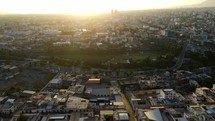 Aerial shot drone flies into the sun setting over Arequipa, Peru