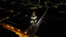 Aerial shot drone semicircle around church tower in Quito at night